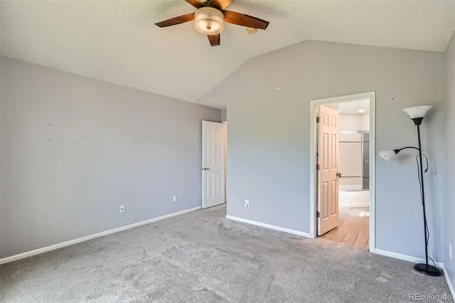 an empty room with closet and a chandelier fan