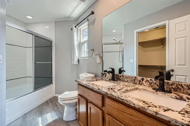 a bathroom with a granite countertop sink toilet and shower