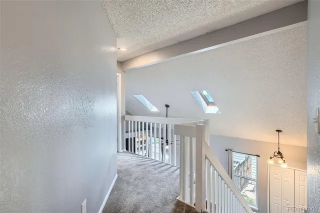 a view of a hallway with windows and stairs