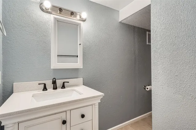 a bathroom with a sink mirror toilet and next to a window