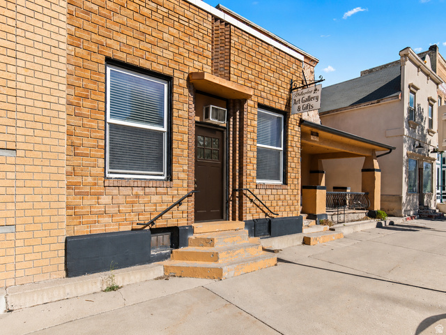 69 South Main Street Manti, UT 84642 - Photo 2 of 44 Brick exterior with a covered entryway, multiple windows, and a black handrail