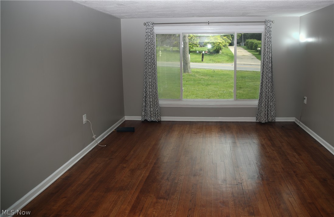 1087 Krumroy Road Akron, OH 44306 - Photo 2 of 23 Spacious interior featuring wood-finish flooring, a large multi-pane window, and neutral gray wall paint