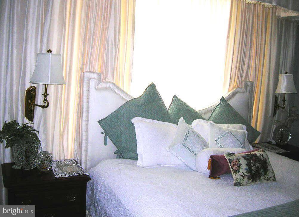 2985 Kabletown Road Charles Town, WV 25414 - Photo 20 of 22 a bed sitting in a bedroom next to a window and potted plants