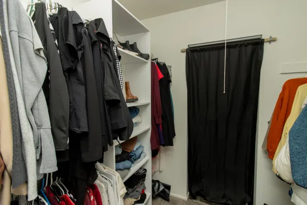 a view of walk in closet with clothes and shoes