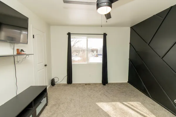 a bedroom with a bed and a flat tv screen on the wall