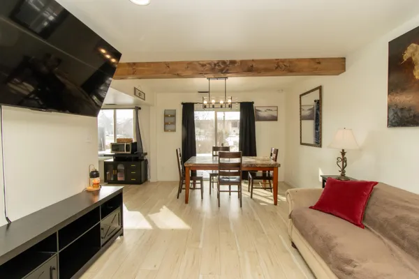 a living room with furniture a flat screen tv and kitchen view