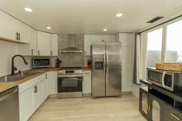 a kitchen with stainless steel appliances granite countertop a stove a sink and a refrigerator