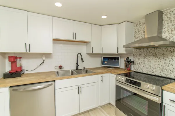 a kitchen with white cabinets and appliances