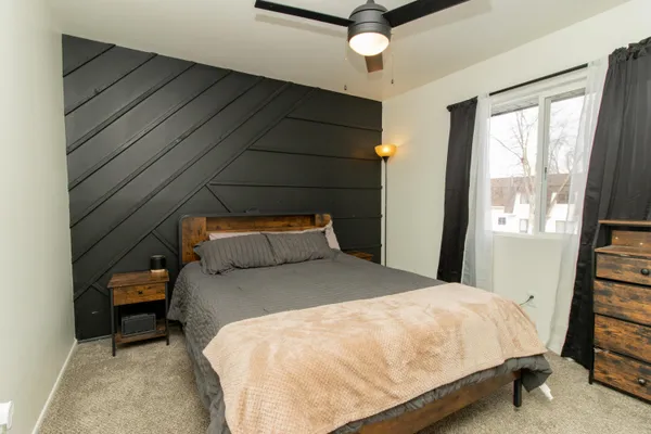 a large bed sitting in a bedroom next to a window