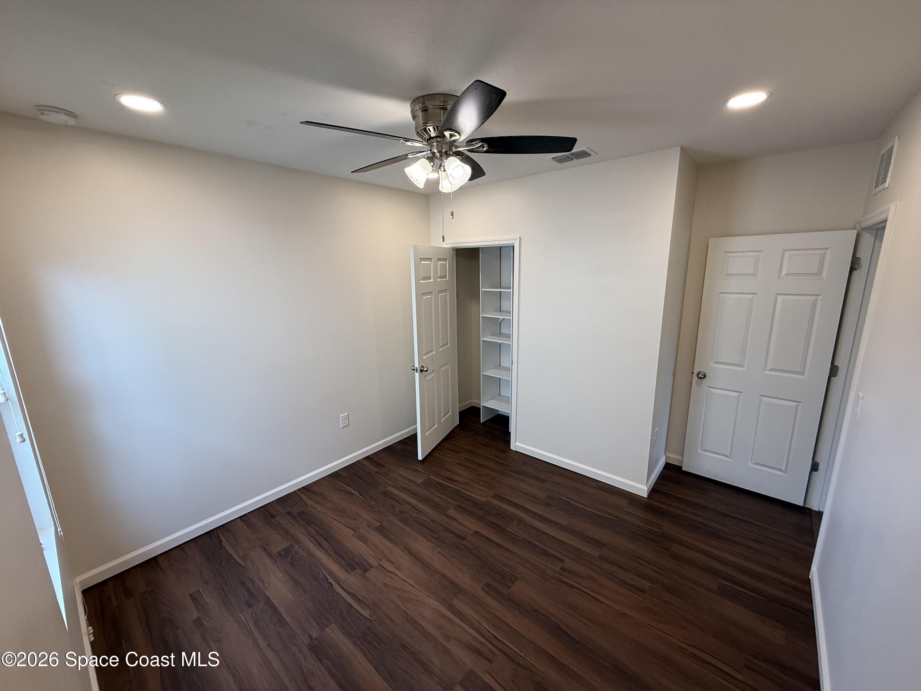 1070 Swiss Pointe Lane Rockledge, FL 32955 - Photo 11 of 18 an empty room with wooden floor a ceiling fan and closet