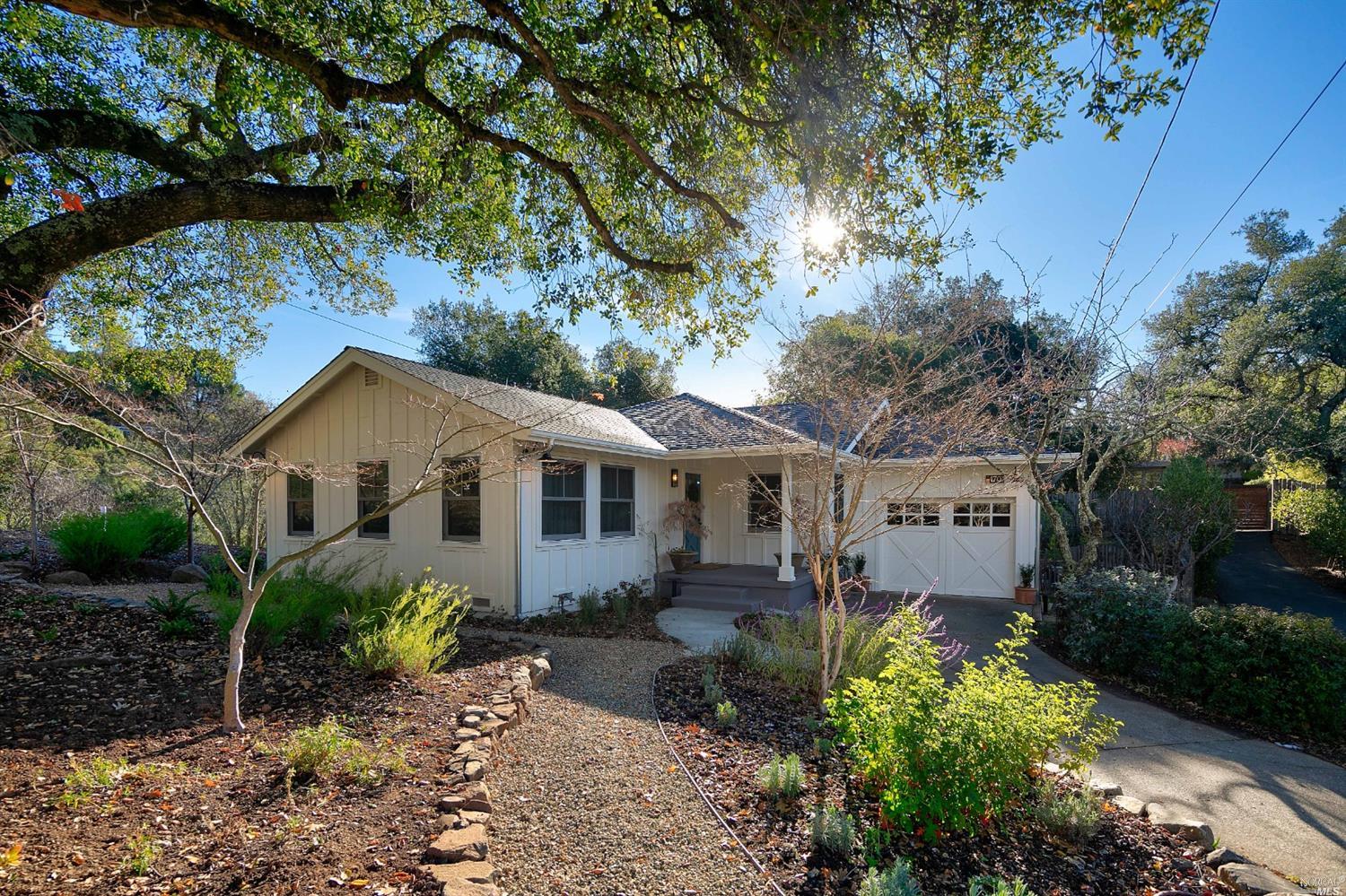 a backyard of a house with garden and outdoor seating