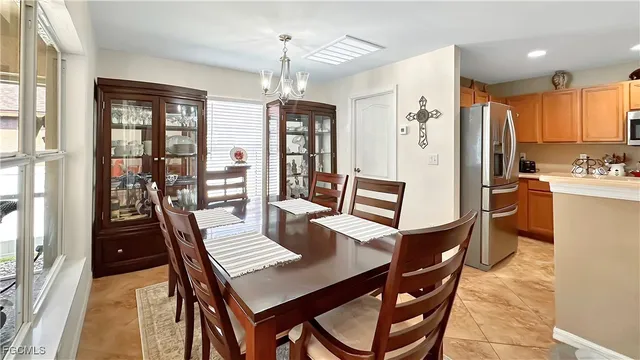 a dining room with furniture a chandelier and wooden floor