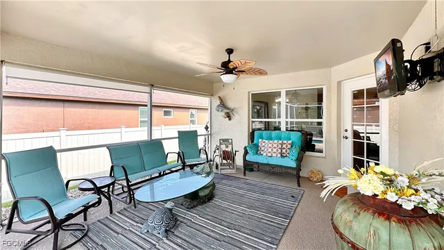 a living room with furniture a flat screen tv and a floor to ceiling window