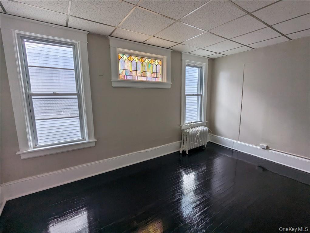 65 Academy Street, Unit 7 Poughkeepsie, NY 12601 - Photo 14 of 19 a view of an empty room with wooden floor and a window
