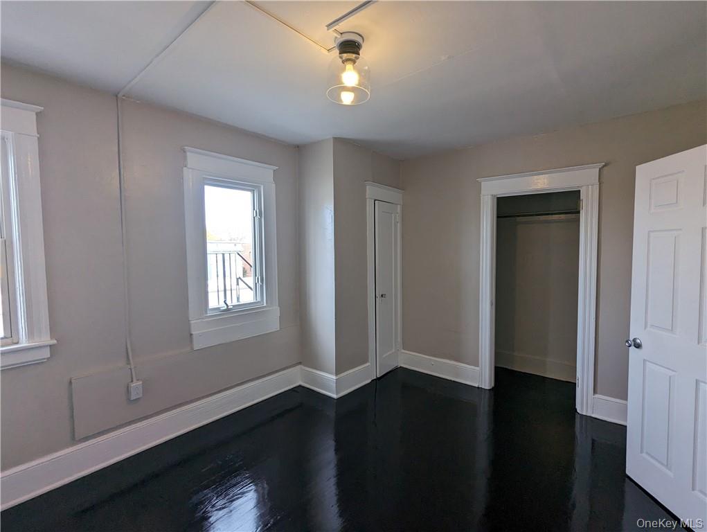 65 Academy Street, Unit 7 Poughkeepsie, NY 12601 - Photo 16 of 19 a view of an empty room with wooden floor and a window