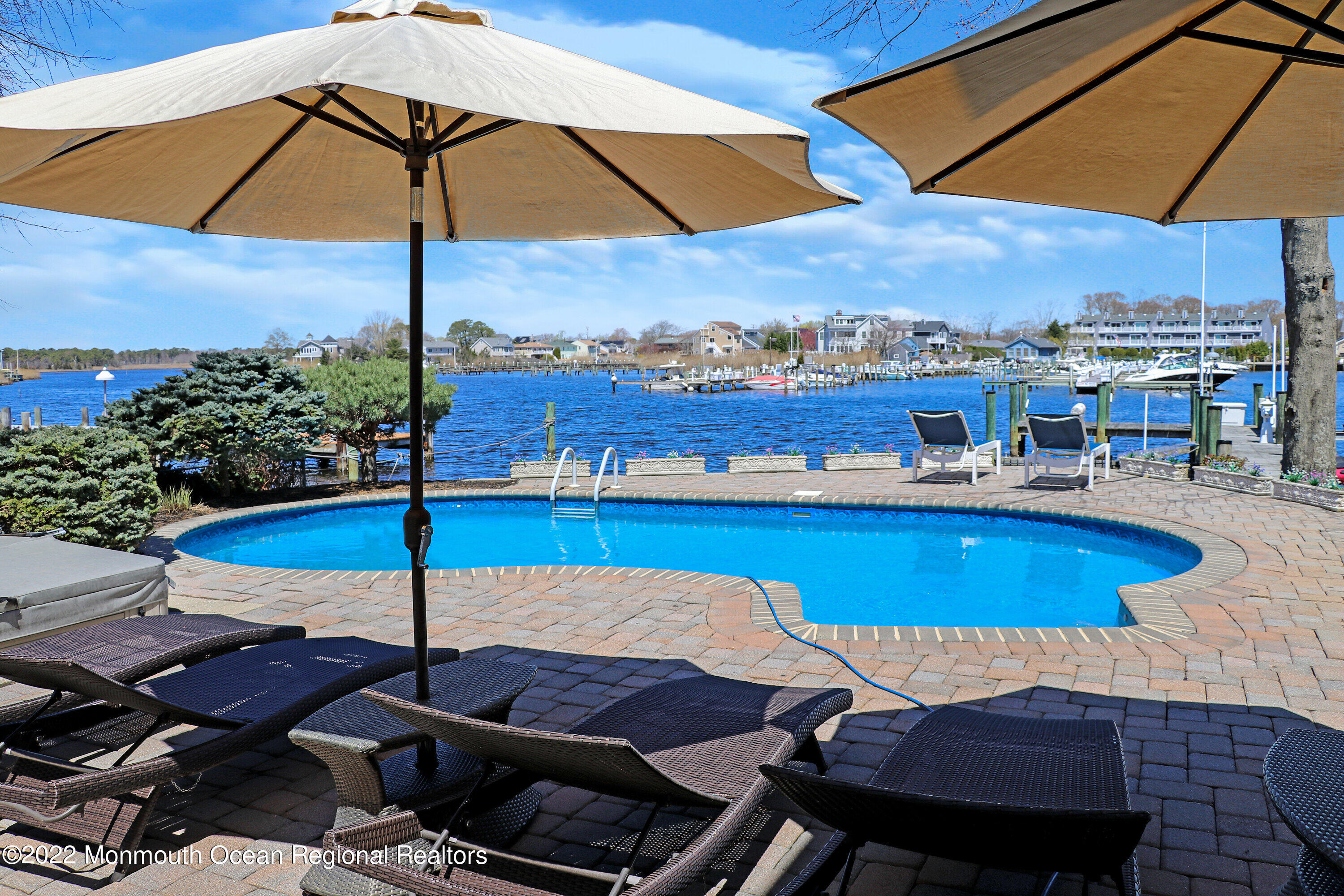 574 Harbor Road Brick, NJ 08724 - Photo 12 of 65 a view of a patio with swimming pool table and chairs under an umbrella