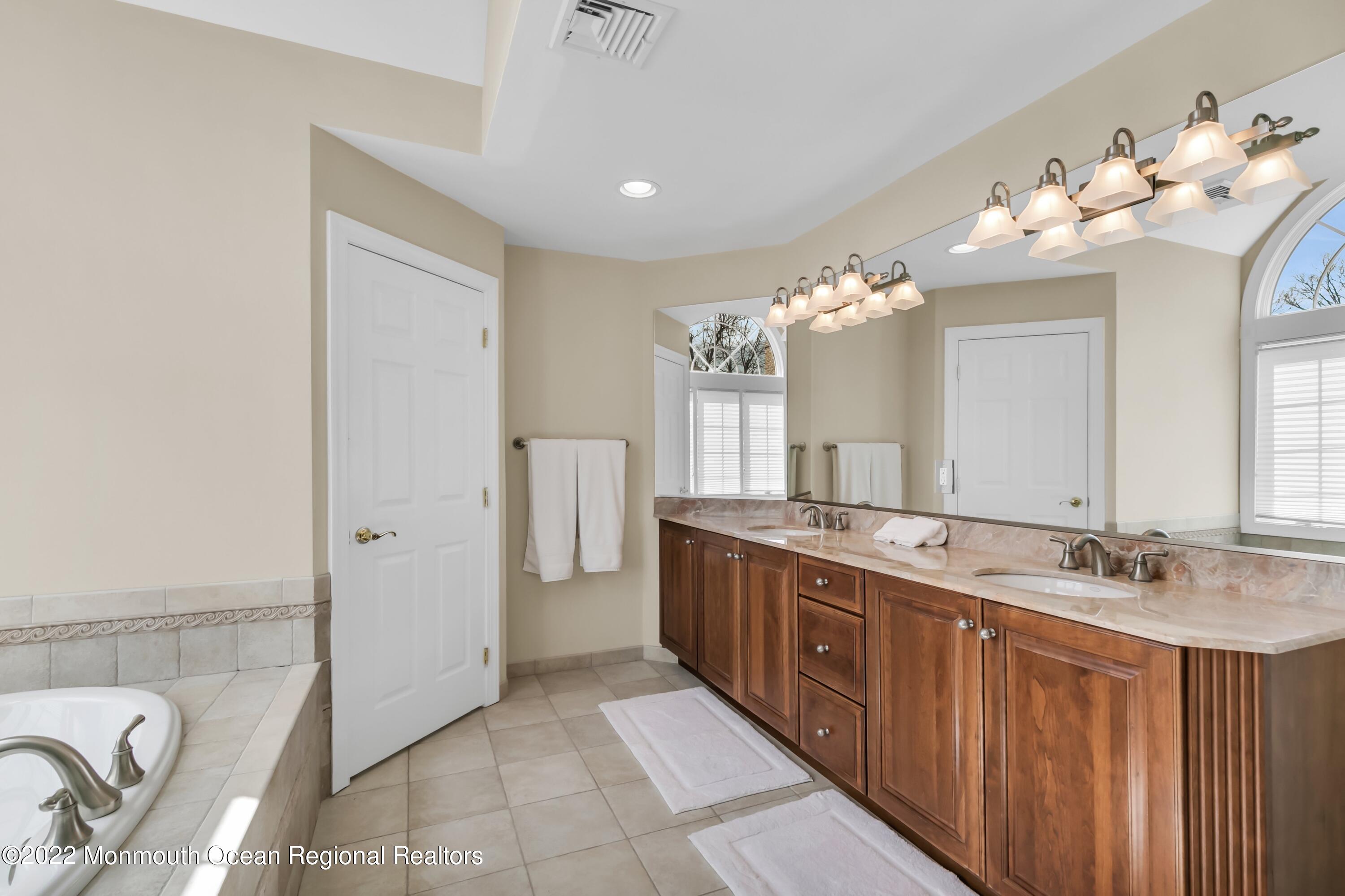 574 Harbor Road Brick, NJ 08724 - Photo 46 of 65 a spacious bathroom with a double vanity sink mirror and chandelier