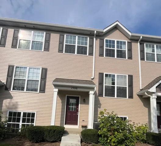 a front view of a house with plants