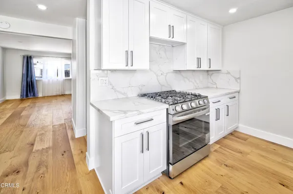 a kitchen with granite countertop a stove top oven and cabinets