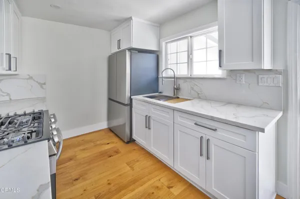 a kitchen with white cabinets and refrigerator