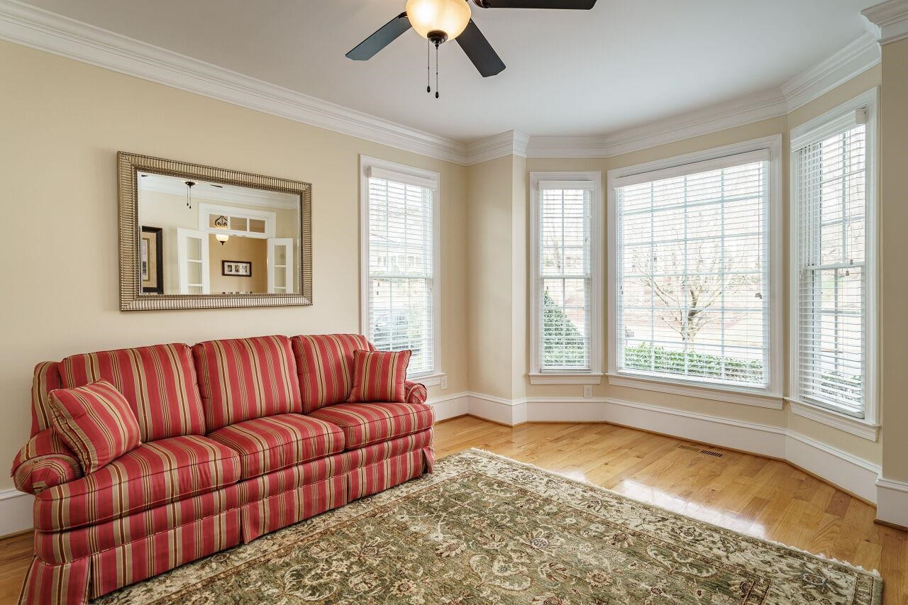 This bedroom on the main level features a bay window, closet, en suite full bathroom, glass french doors and great space for a guest bedroom or home office. Main Floor Bedroom