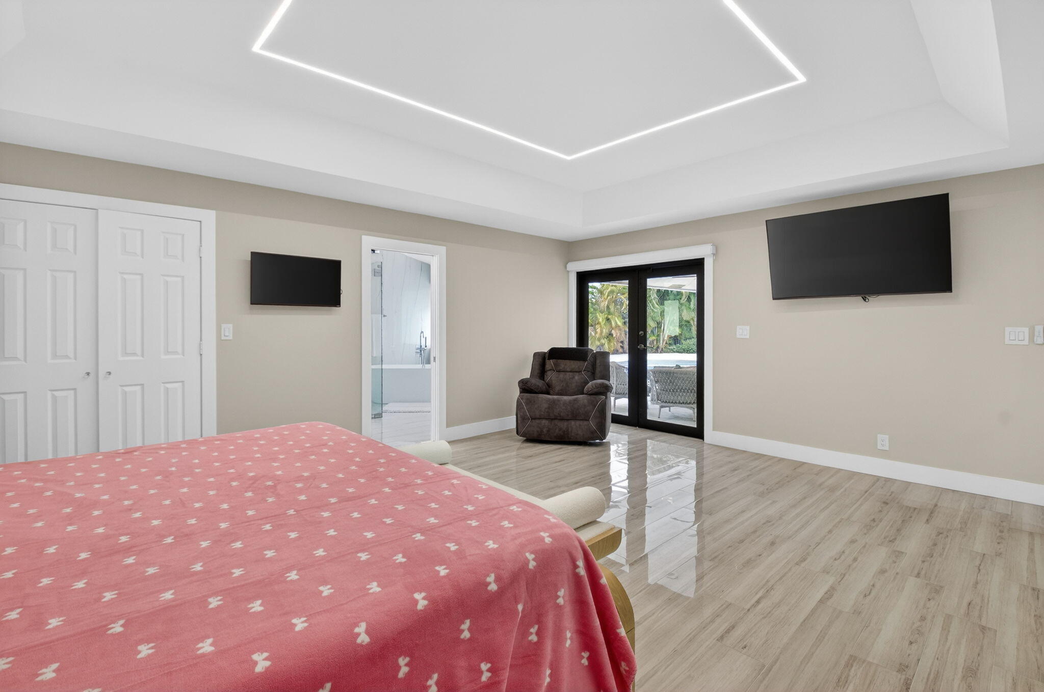 2871 Northwest 49th Street Boca Raton, FL 33434 - Photo 30 of 60 a spacious bedroom with a bed and a flat screen tv