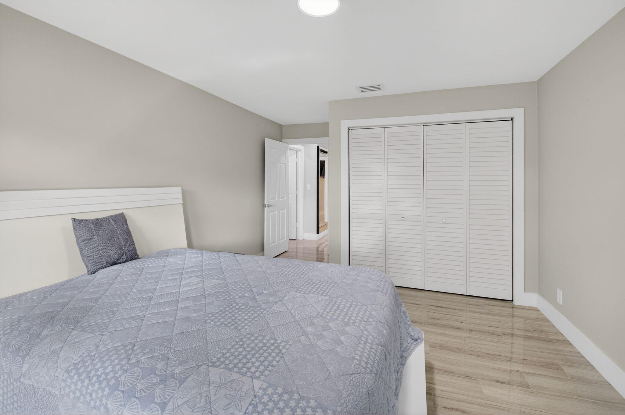 2871 Northwest 49th Street Boca Raton, FL 33434 - Photo 39 of 60 a large bedroom with a bed and wooden floor