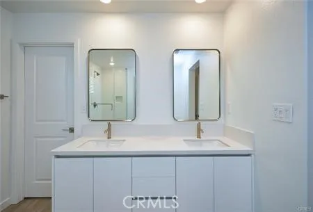 a bathroom with double vanity sinks and a mirror