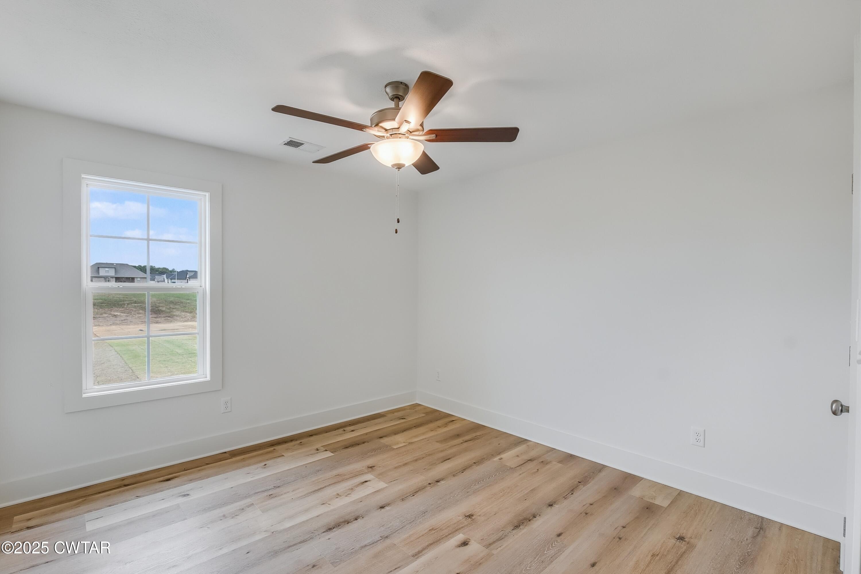110 Daybreak Loop Medina, TN 38355 - Photo 16 of 21 an empty room with wooden floor fan and windows