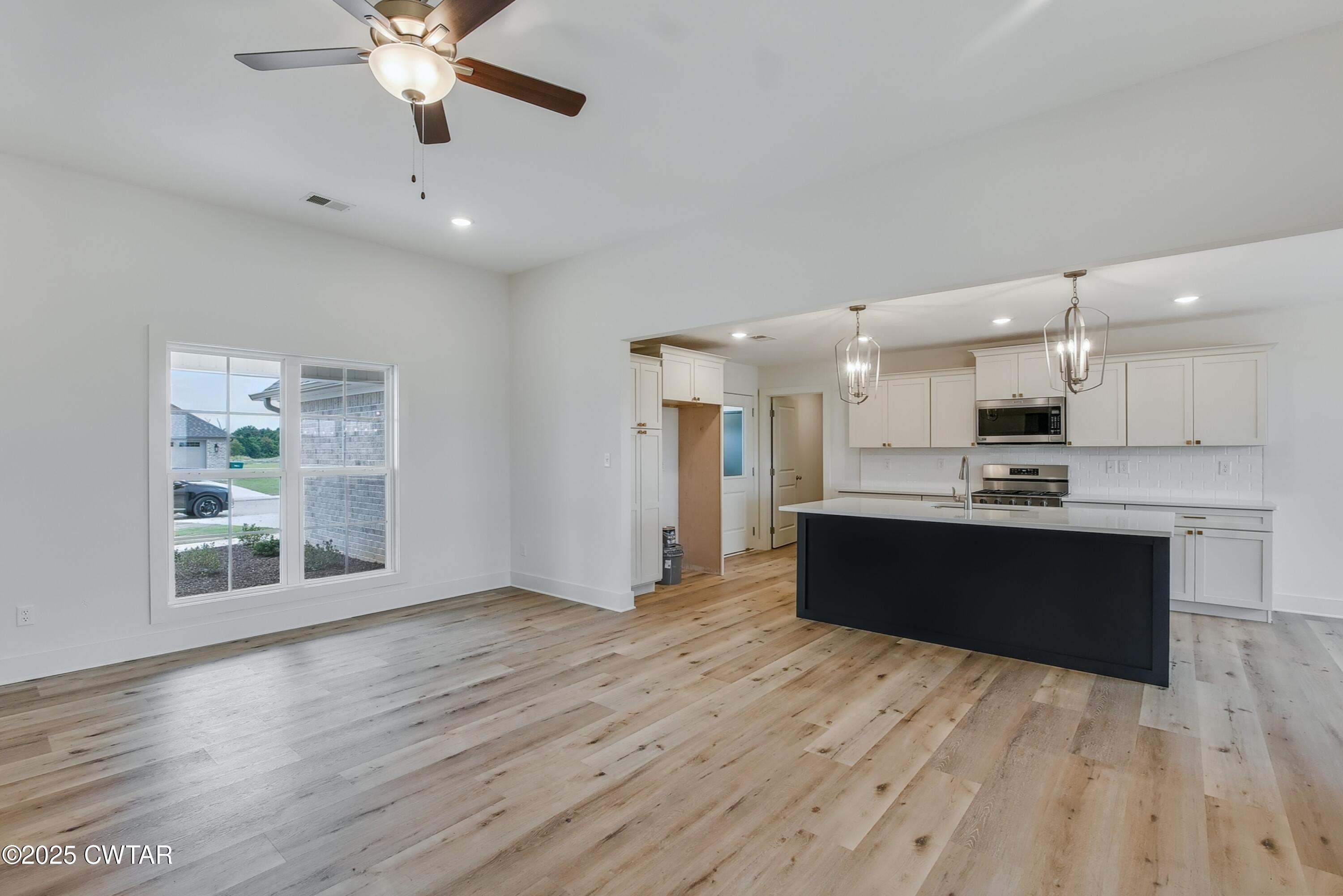 110 Daybreak Loop Medina, TN 38355 - Photo 6 of 21 a large kitchen with stainless steel appliances kitchen island granite countertop a large cabinets a sink and a wooden floor