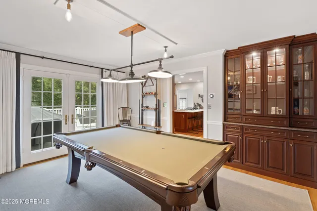a room with pool table and windows