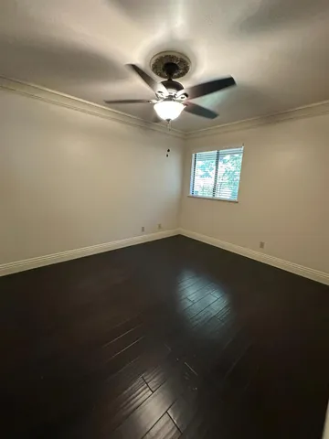 a view of wooden floor and a chandelier fan in a room