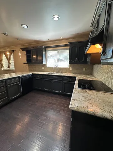 a kitchen with stainless steel appliances granite countertop a sink and a stove
