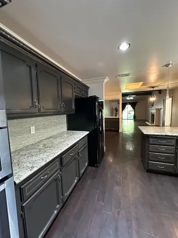 a kitchen with stainless steel appliances granite countertop a stove a sink and a refrigerator