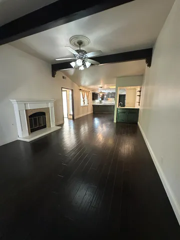 a view of a livingroom with furniture chandelier fan and wooden floor