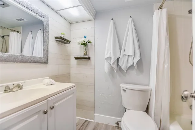 a bathroom with a sink mirror vanity and toilet