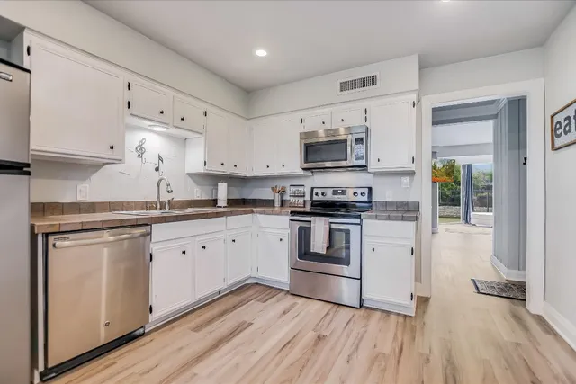 a kitchen with granite countertop white cabinets and white appliances