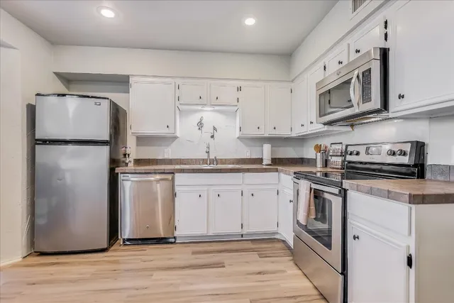 a kitchen with stainless steel appliances granite countertop a refrigerator sink and stove