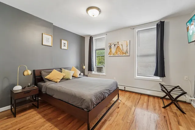a bedroom with a bed and wooden floor