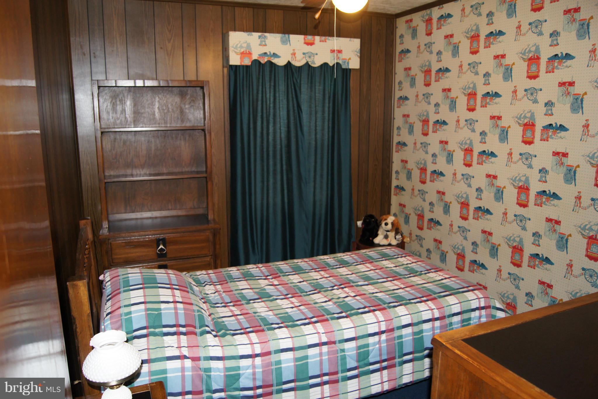 1906 Searles Road Baltimore, MD 21222 - Photo 8 of 13 a bedroom with a bed and a chair with the wooden floor