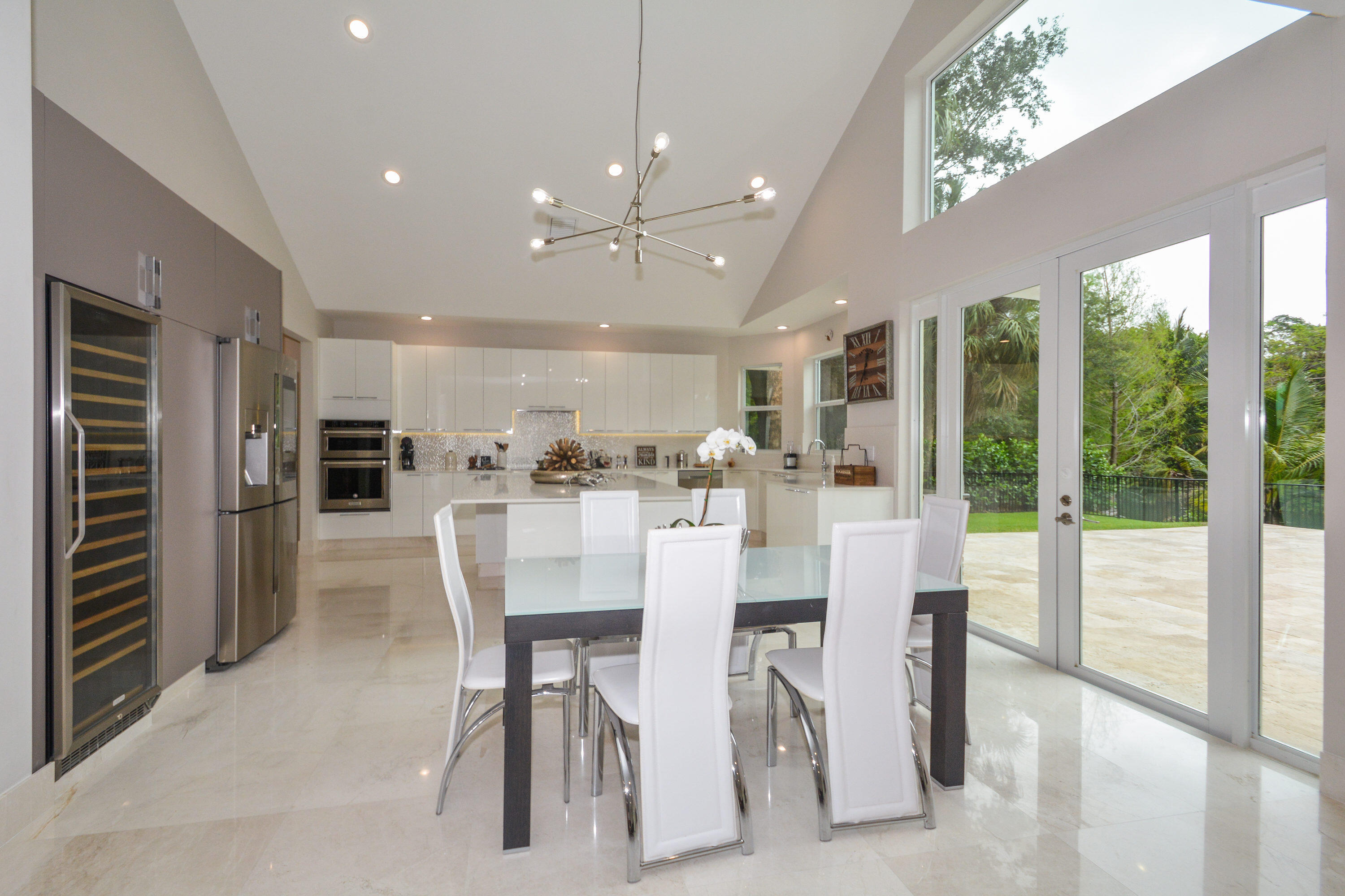 934 Southwest 21st Way Boca Raton, FL 33486 - Photo 6 of 25 a dining room with stainless steel appliances kitchen island granite countertop a refrigerator and cabinets