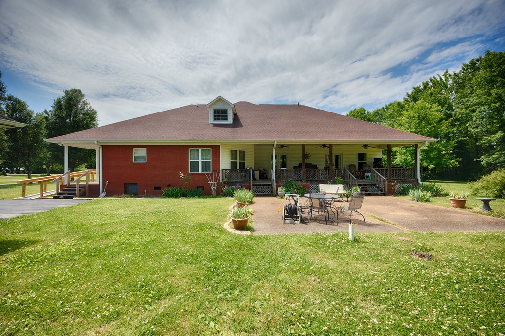 84 Scott Orchard Road Taft, TN 38488 - Photo 5 of 23 a patio with a table and chairs under an umbrella
