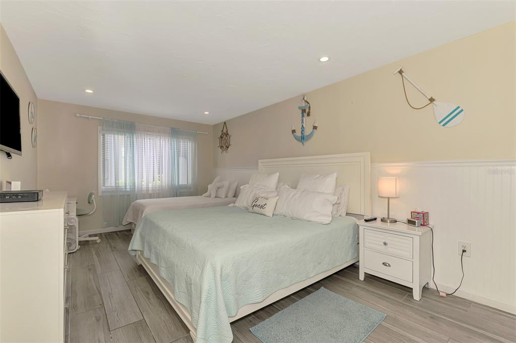 1612 Stickney Point Road, Unit 16121 Sarasota, FL 34231 - Photo 20 of 39 a bedroom with a bed and a flat screen tv