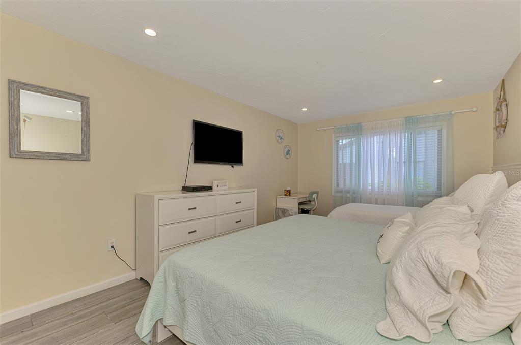 1612 Stickney Point Road, Unit 16121 Sarasota, FL 34231 - Photo 21 of 39 a bedroom with a bed and a flat screen tv