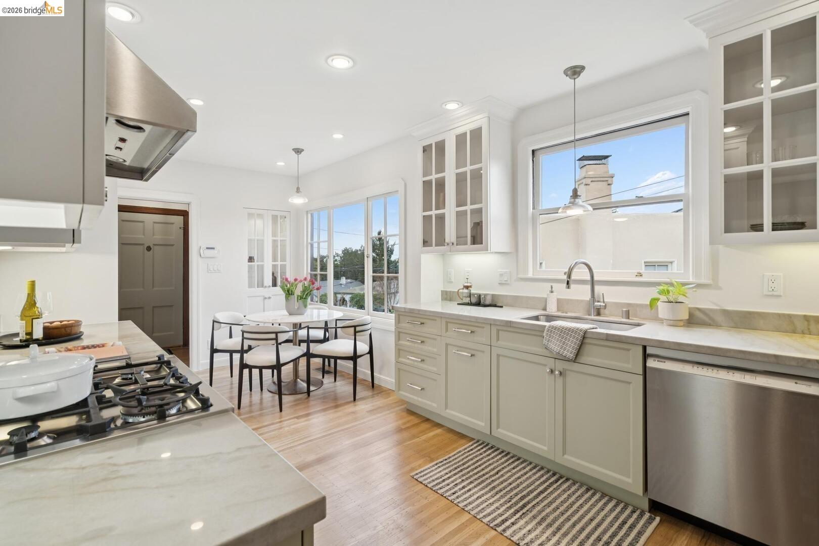 4107 Lyman Road Oakland, CA 94602 - Photo 13 of 57 Kitchen with stainless steel appliances, pendant lighting, white cabinets, light wood-style flooring, and light stone counters