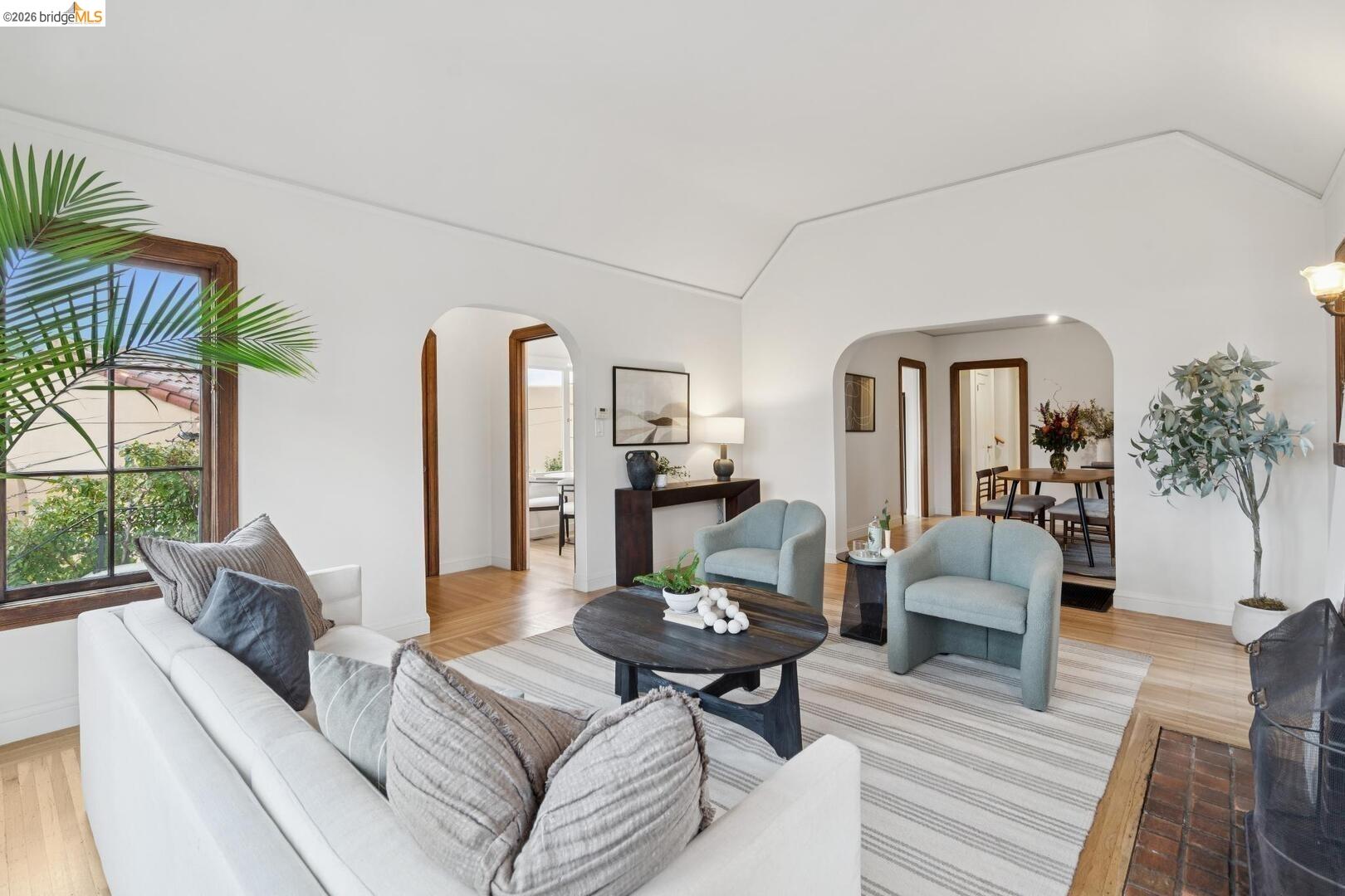 4107 Lyman Road Oakland, CA 94602 - Photo 10 of 57 Living area featuring a fireplace, healthy amount of natural light, wood finished floors, arched walkways, and lofted ceiling