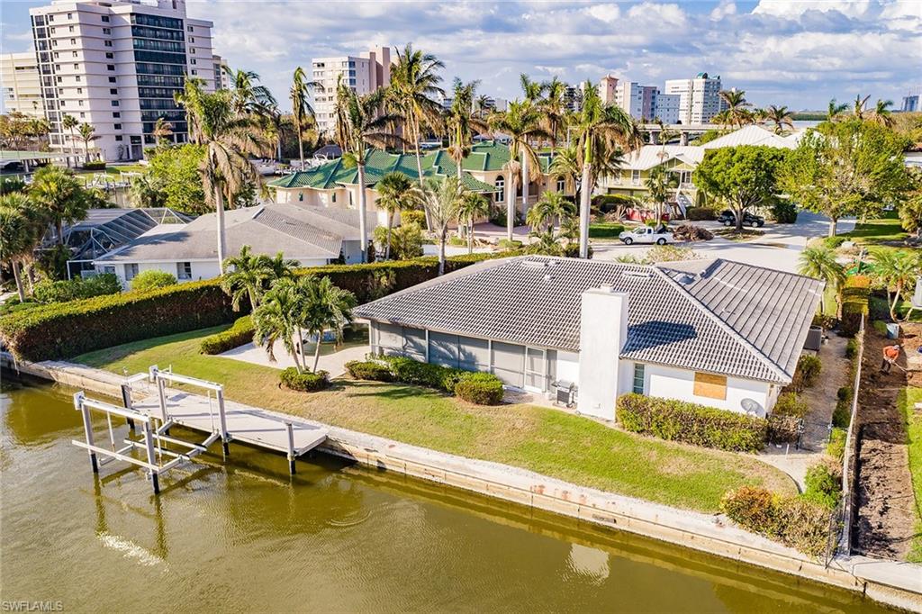 128 Heron Avenue Naples, FL 34108 - Photo 2 of 12 a view of a swimming pool with outdoor seating space