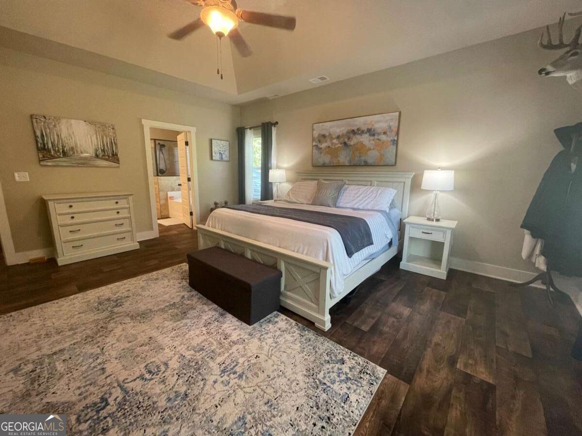 457 Old Good Hope Road Good Hope, GA 30641 - Photo 12 of 59 a spacious bedroom with a bed a dresser and painting on the wall