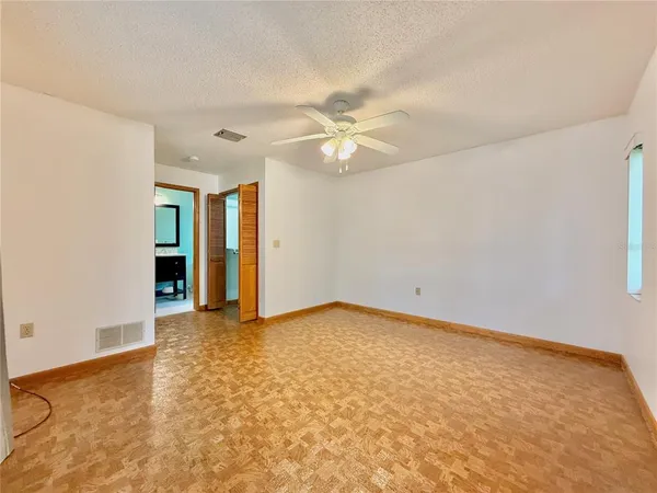 an empty room with an entryway and fan
