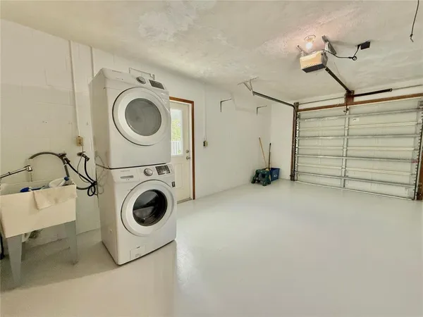 a view of an empty room with washing machine and a sink